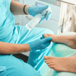 A doctor preparing a foot wound debridement.