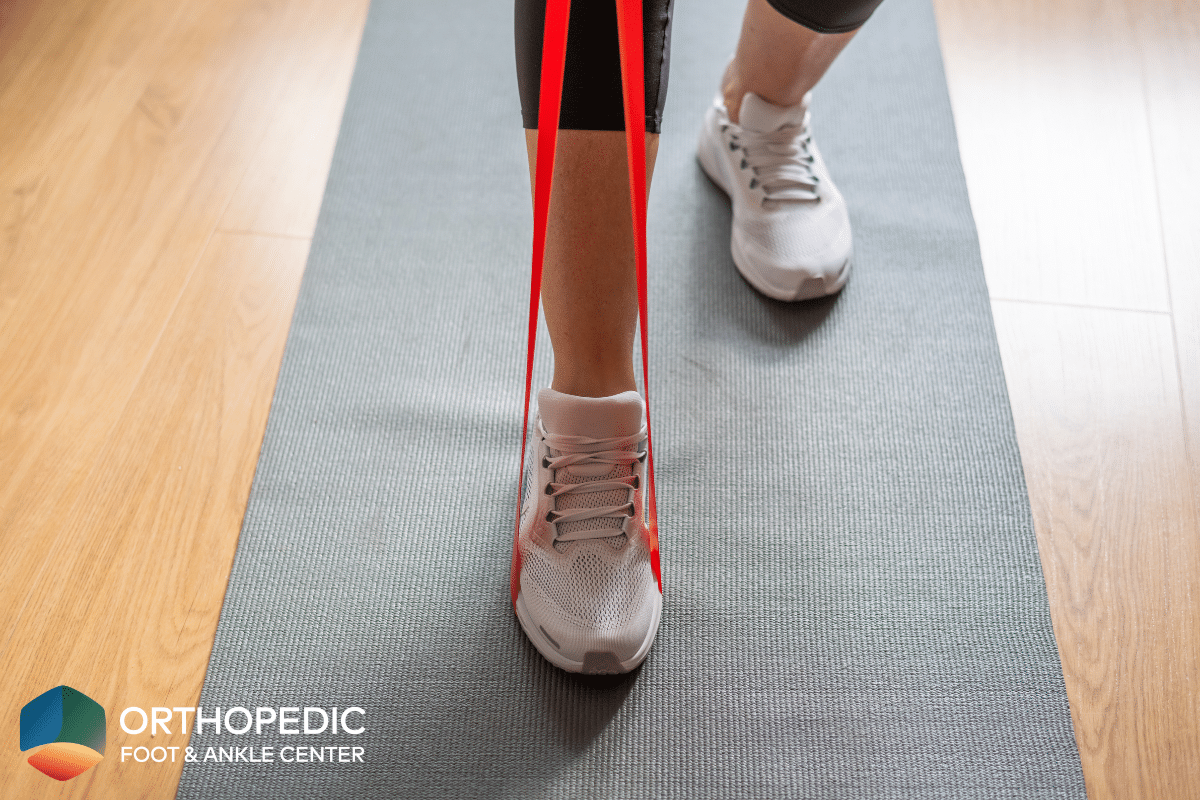 A woman using a resistance band to do exercises to strengthen her foot and ankle in Ohio.